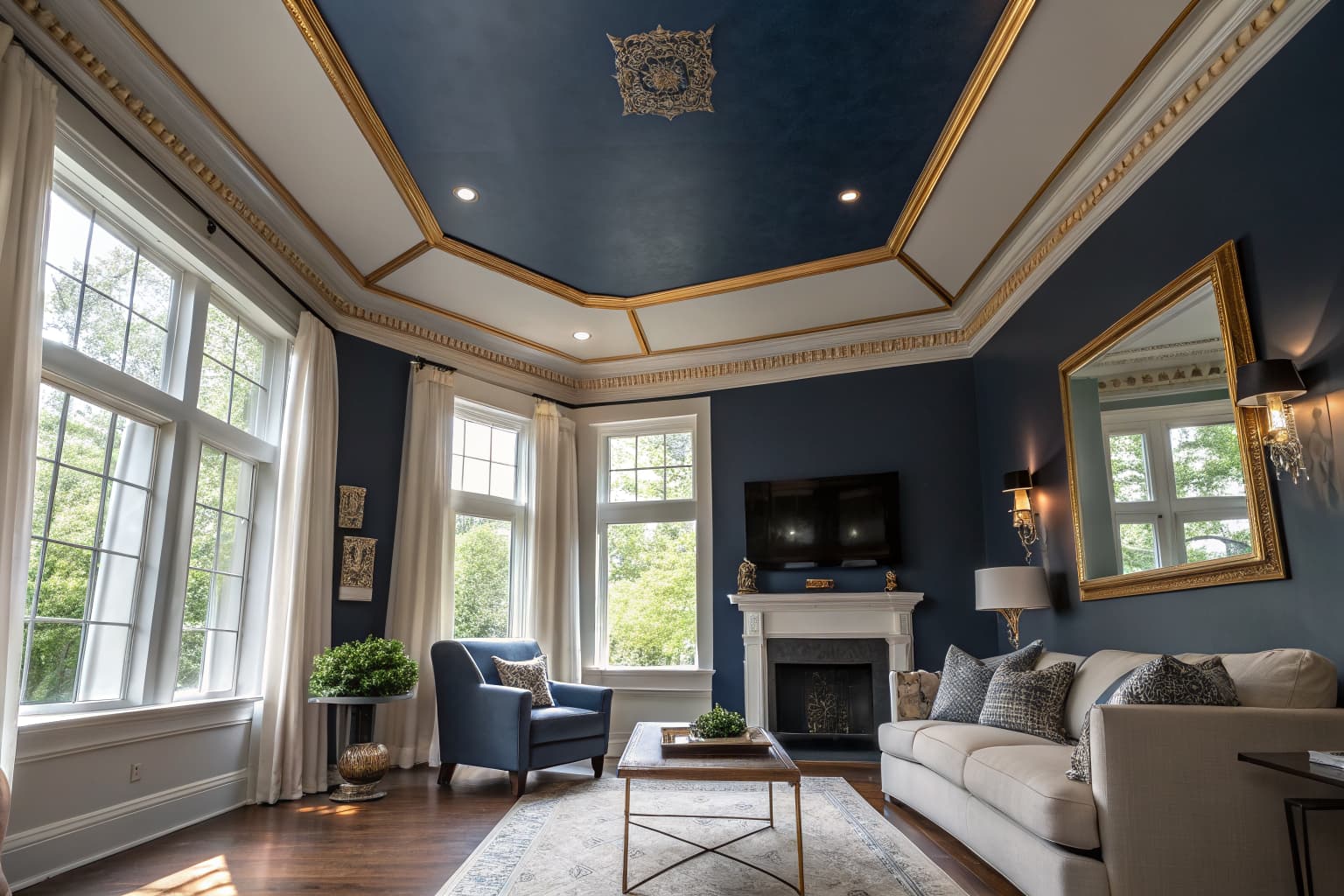 Elegant living room with deep navy color-capped ceiling and golden trim