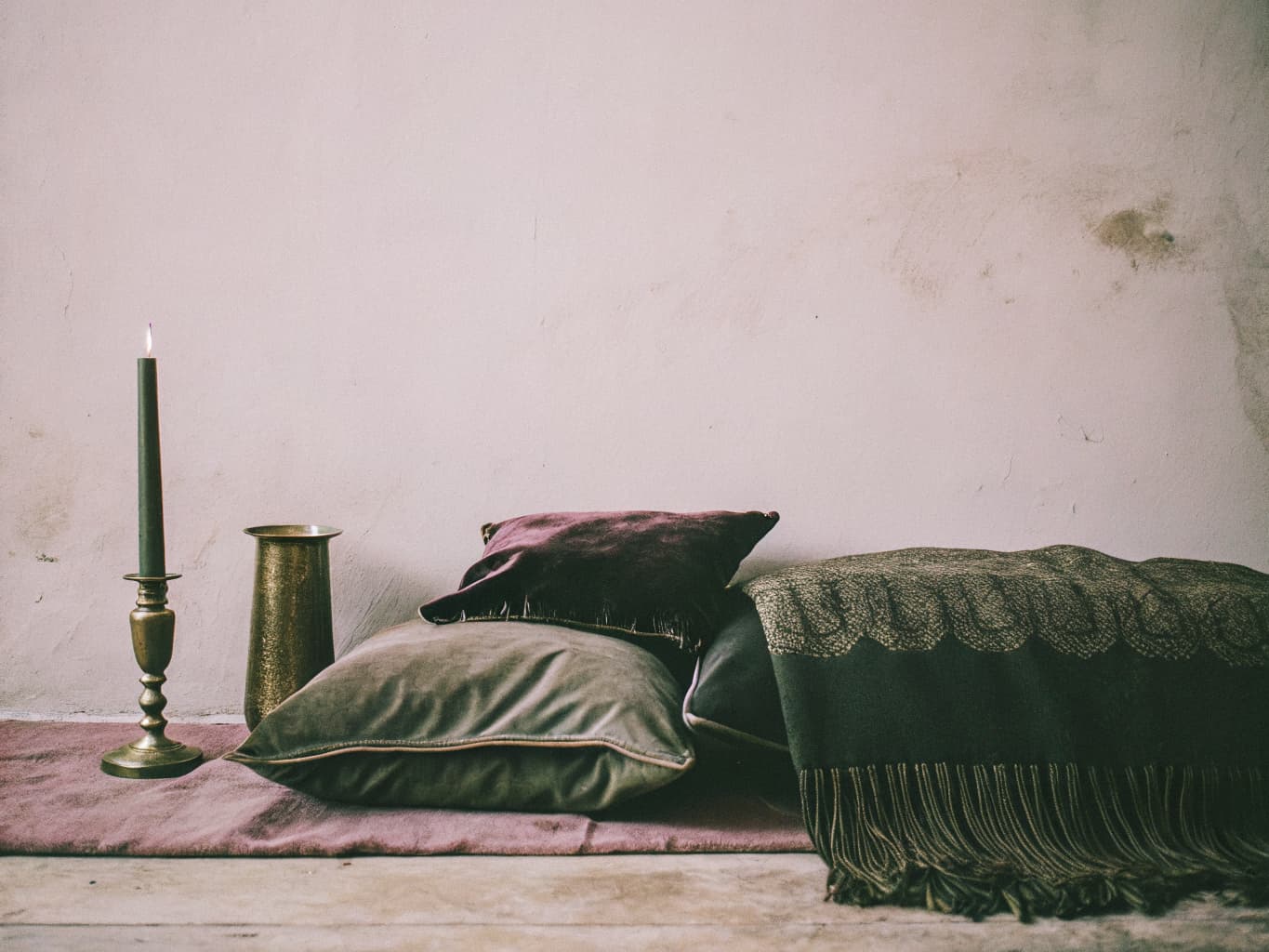 Rich jewel-toned accents — deep burgundy velvet, forest olive, and brass — softening an earthy palette