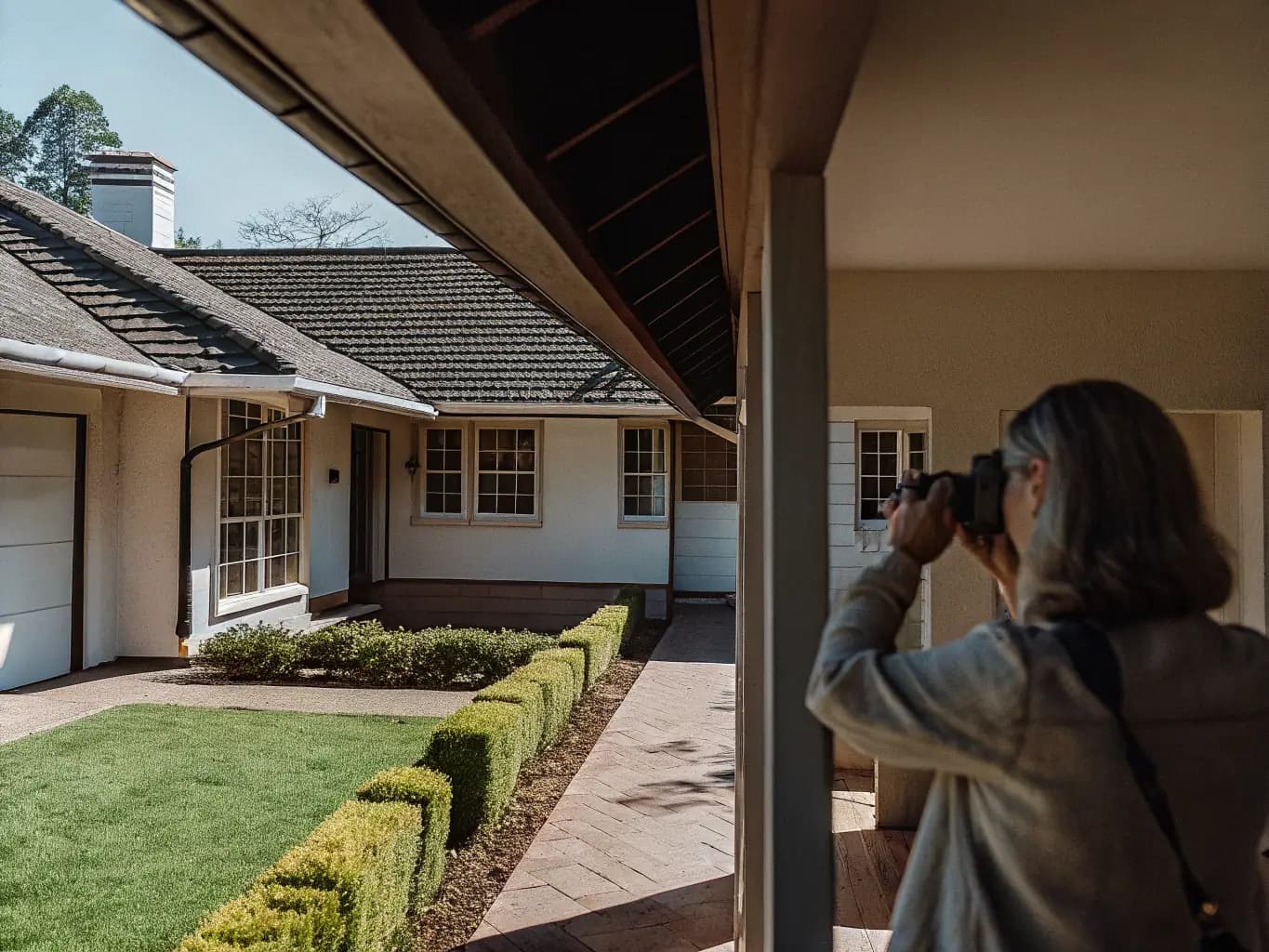 Property manager inspecting and documenting a well-maintained home on behalf of an absentee owner