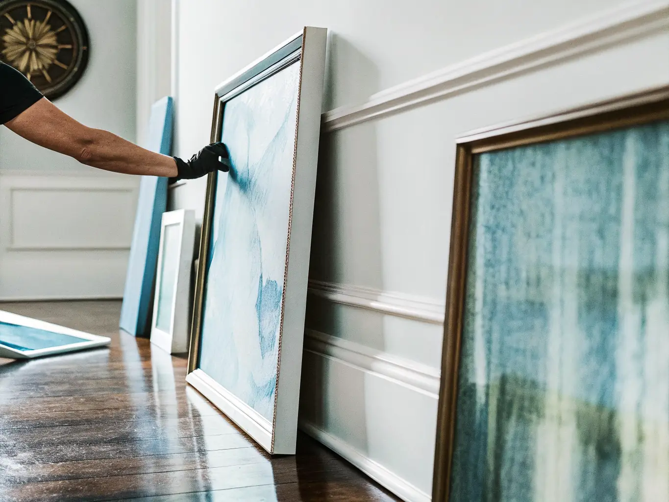 Professional art placement service carefully positioning artwork in a luxury home